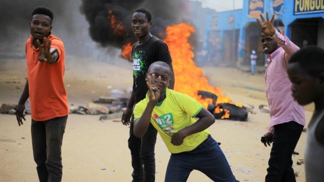 Supporters of Congolese joint opposition Presidential candidate Martin Fayulu, gesture as they protest over their exclusion from the presidential election in Beni, Democratic Republic of Congo