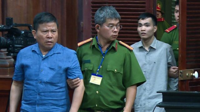 Chau Van Kham is escorted into court by police