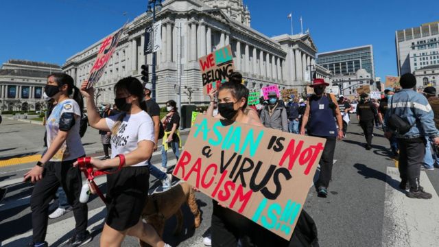Demonstrators hold up signs as they take part in an anti-Asian American hate march and rally at San Francisco City Hall in San Francisco, Calif