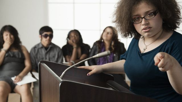 Una chica debatiendo en público