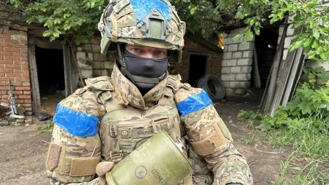 A Ukrainian soldier holds a Russian mine
