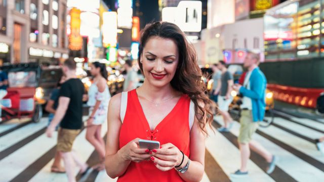 Una mujer mira su celular en Times Square, Nueva York