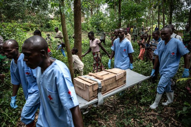 The Red Cross burial workers carry a box containing the body of an 11-month-old girl