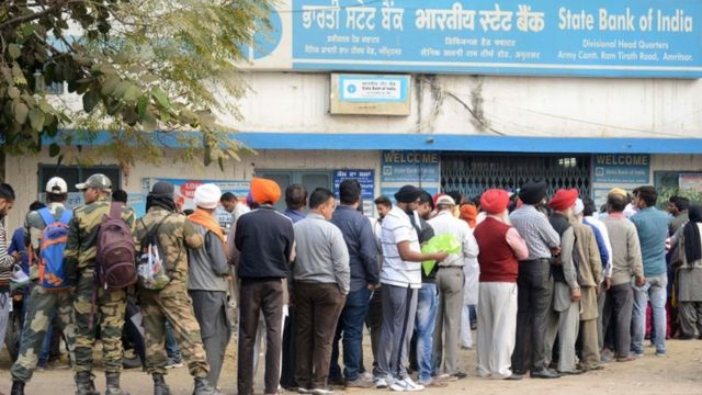 पैसे निकालने, जमा करने और बदलने के लिए पंजाब में कतार में खड़े लोग.