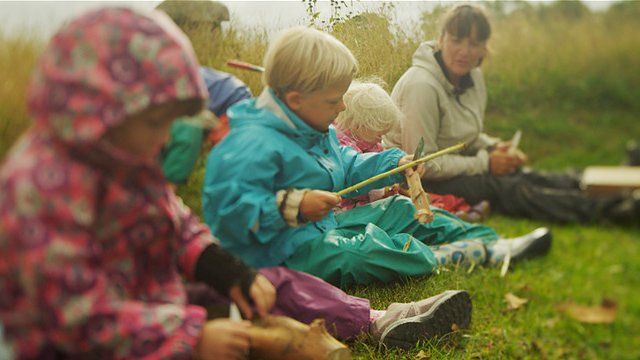 Professora orienta crianças enquanto elas manuseiam facas em cena do filme "Nature Play"