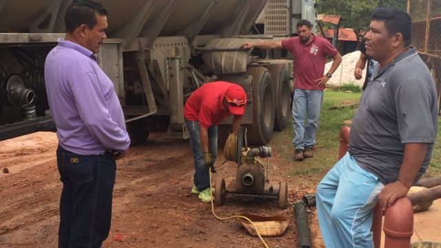 Unos empleados llenar de gasolina los surtidores de la bomba