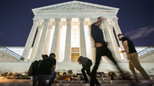 People leave flowers at the Supreme Court of the United States.