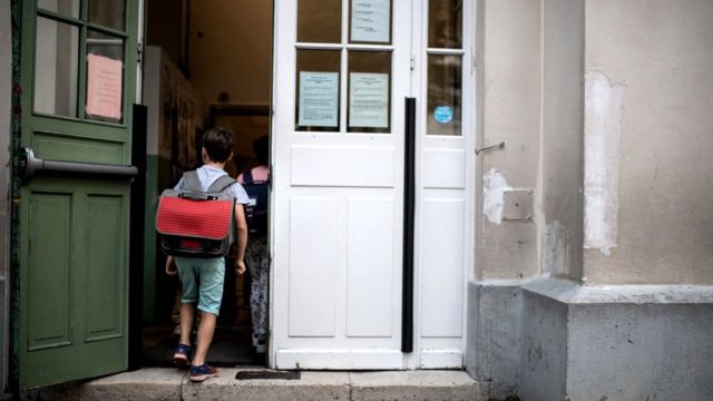 A boy enters in his classroom at the Chaptal elementary school in Paris, 2 September 2019