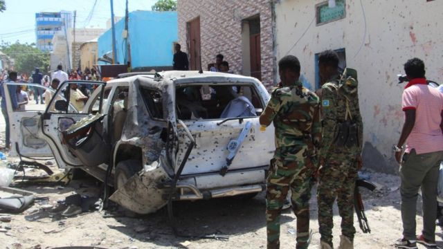 Government soldiers look at the scene of suicide bomb attack in Mogadishu on January 16, 2022.