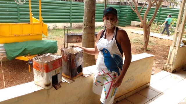 Anely ao lado do seu fogareiro de carvão.