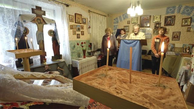 Svetlana and other residents pray in a Ukrainian Orthodox Church, situated in the basement of her charity's office.