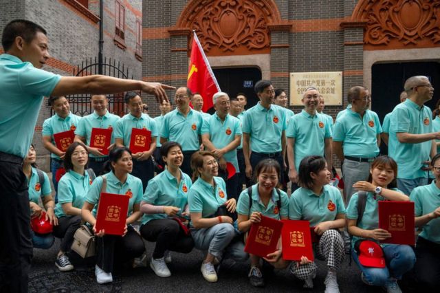 A group of tourists took a group photo in front of the site of the First Congress of the Communist Party of China in Shanghai.