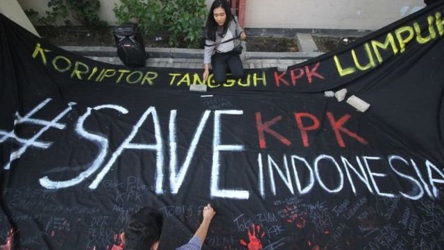 Mahasiswa membubuhkan tanda tangan dan cap telapak tangan pada spanduk hitam saat menggelar aksi #SaveKPK di Universitas Airlangga (Unair), Surabaya, Jawa Timur, Selasa (10/09).