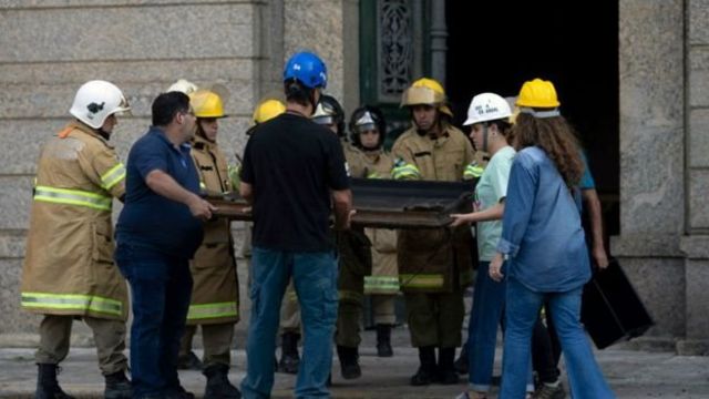 Trabajadores retiran un cuadro quemado del Museo Nacional tras el incendio