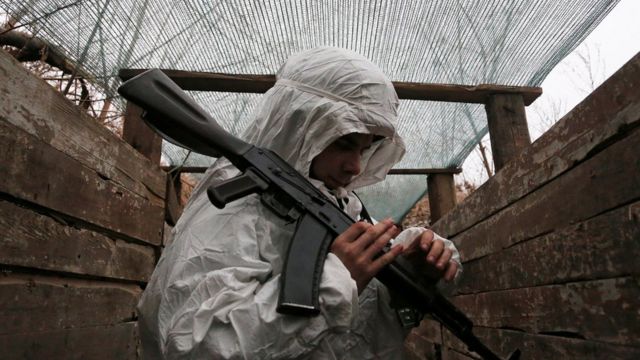 Um militante da autoproclamada República Popular de Donetsk (DNR) segura uma arma em posições de combate na linha de separação das forças armadas ucranianas perto do assentamento controlado pelos rebeldes de Yasne (Yasnoye) na região de Donetsk, Ucrânia 14 de janeiro de 2022