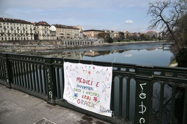 'Médicos e enfermeiros são nossos heróis, obrigado', diz uma placa pendurada na ponte Vittorio Emanuele, em Turim