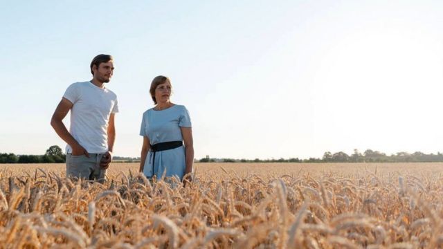 نادية وابنها دميترو يقفان في أحد حقول القمح.