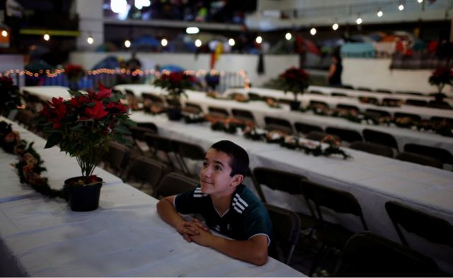 A migrant, part of a caravan of thousands from Central America trying to reach the United States, celebrates Christmas, at a temporary shelter in Tijuana, Mexico