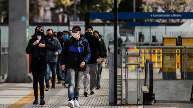 Pessoas andam na rua de máscara em Buenos Aires