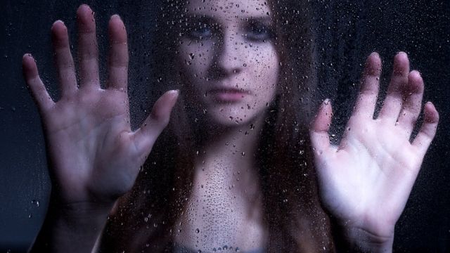 Женщина за стеклом с каплями