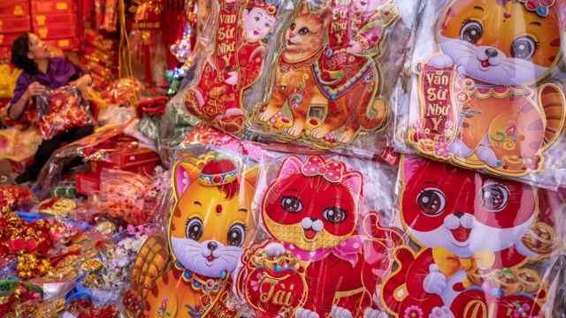Adesivos com imagens de um gato em exposição na feira Tet no bairro antigo de Hanói, Vietnã
