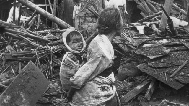 Una mujer acarrea un bebé herido en los bombardeos en las calles de Pyongyang.
