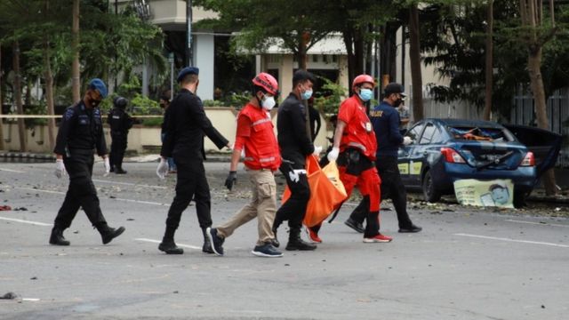 Red Cross personnel carry a body bag following an explosion outside a Catholic church in Makassar