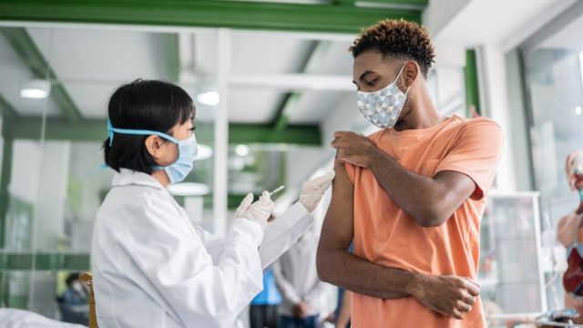 Rapaz adolescente recebendo vacina no braço