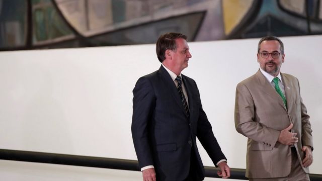 Jair Bolsonaro e de Abraham Weintraub sorriem enquanto conversam e descem rampa no Palácio do Planalto