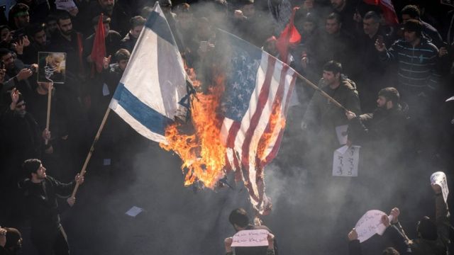 Banderas de EE.UU. e Israel en fuego.