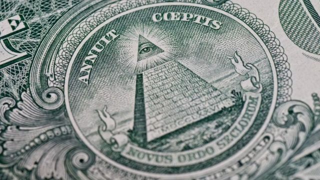 คนที่เชื่อในทฤษฎีสมคบคิดมองว่า สัญลักษณ์บนธนบัตรเงินดอลลาร์สหรัฐฯ สื่อถึงอิทธิพลของอิลลูมินาติ