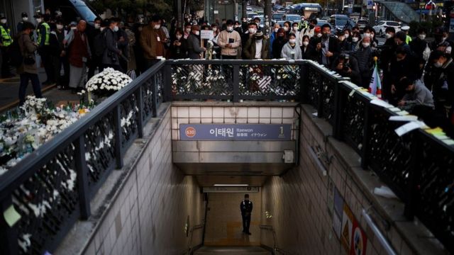 A police officer stands guard at the exit of a subway station as people gather to pay their respects following a crowd crush that happened during Halloween festivities, in Seoul, South Korea, November 1, 2022.