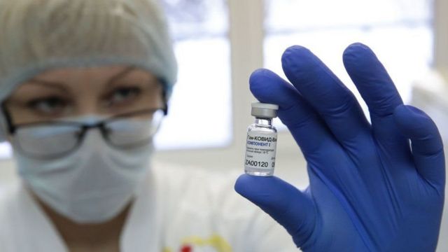 باحثة روسية تحمل أمبولا للقاح روسي مضاد لكوفيد-19