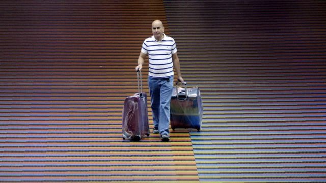 A man walks with two suitcases at Maiquetía airport