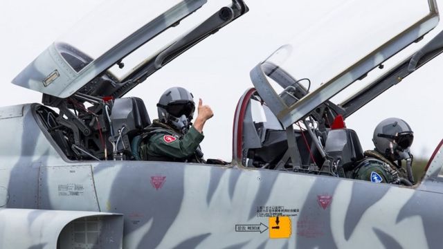 Hsiung Hou-chi (L) gives a thumbs up from aboard an F-5 fighter jet