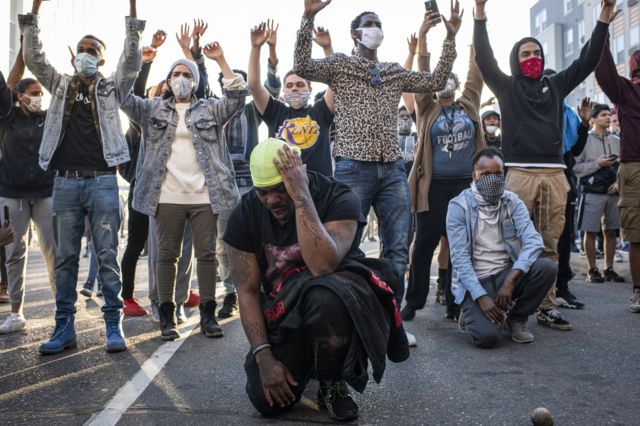 11. Demonstrators hold their hands up and take a knee during protests resulting from the killing of an unarmed black man, George Floyd, by police.