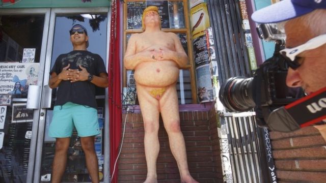Мужчина позирует рядом со статуей Дональда Трампа в Лос-Анджелесе