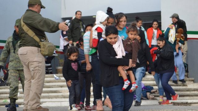 Un policía dirige a los inmigantes rescatados cuando viajaban en un camión tratando de llegar a Estados Unidos.