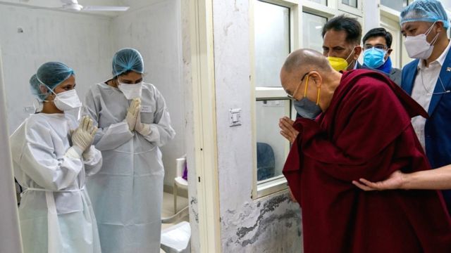 Tibetan spiritual leader the Dalai Lama (R) greets the medical staff after receiving a Covid-19 vaccine in Dharmsala, India, 6 March 2021