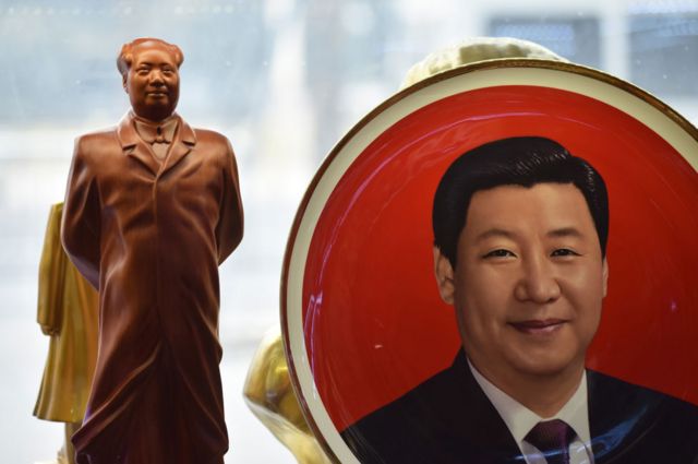 Prato decorado com a imagem de Xi Jinping ao lado de uma estátua de Mao