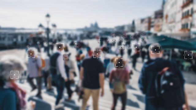 Personas en una multitud siendo identificadas por tecnología de reconocimiento facial
