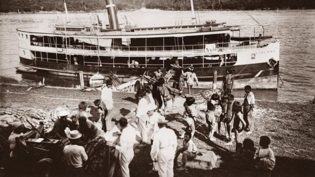 Indigenas subiendo la carga a una embarcación en el río