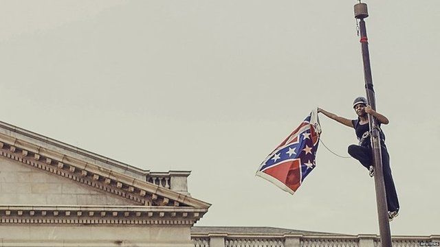 Bree Newsome takes down the Confederate Flag from a pole at the Statehouse in Columbia, South Carolina, June 27, 2015.