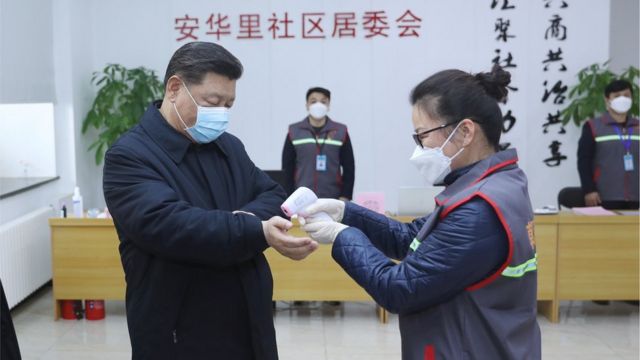 Chinese president Xi Jinping has his temperature recorded during a trip to a hospital in Beijing