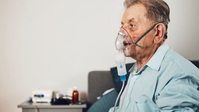 An elderly man receiving oxygen.