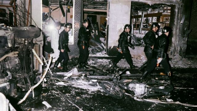 يقف أعضاء فريق الإنقاذ وسط حطام سيارة بعد انفجار قنبلة في 3 أكتوبر 1980 في كنيس شارع كوبرنيك في باريس