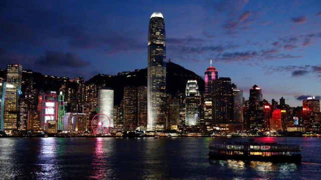 Puerto Victoria frente a un horizonte de edificios en Hong Kong con montañas detrás de ellos