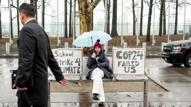 Alexandria Villaseñor sentada frente a la ONU con un cartel que dice "School strike 4 climate" o "Huelga estudiantil por el clima".