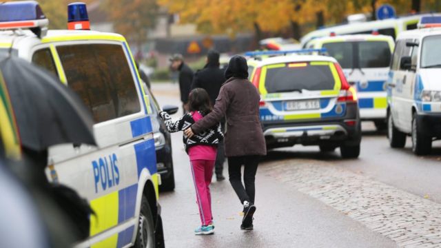 Students and parents leaving the school after a masked man attacked people with a sword at the Kronan school in Trollhaettan in western Sweden 22 October 2015.