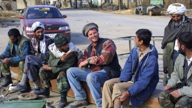 یک سرباز آمریکایی در دسامبر ۲۰۰۱ با افراد محلی خارج از پایگاه شوخی می کند